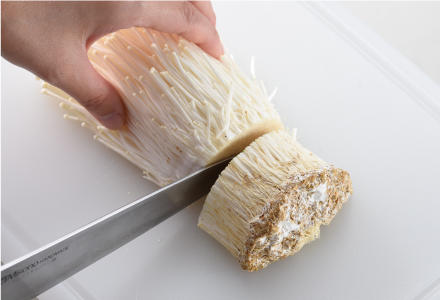 根元を切り、半分に切るえのき茸1
